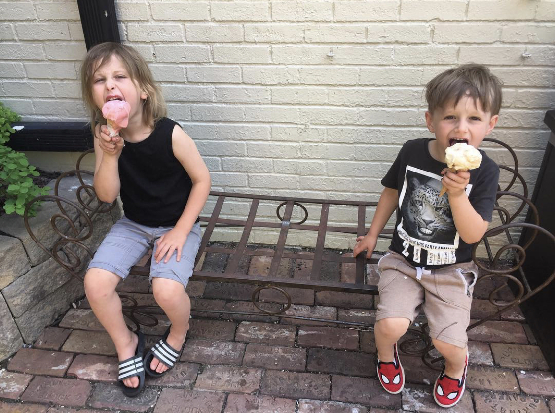 two kids enjoying large ice cream cones